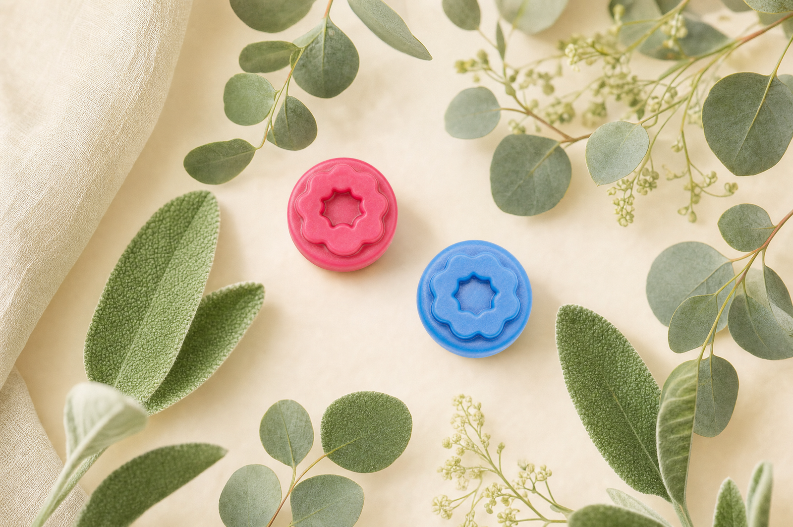 Gomitas de creatina Fills rosa y azul entre hojas de salvia y eucalipto, ambiente sereno para la menopausia